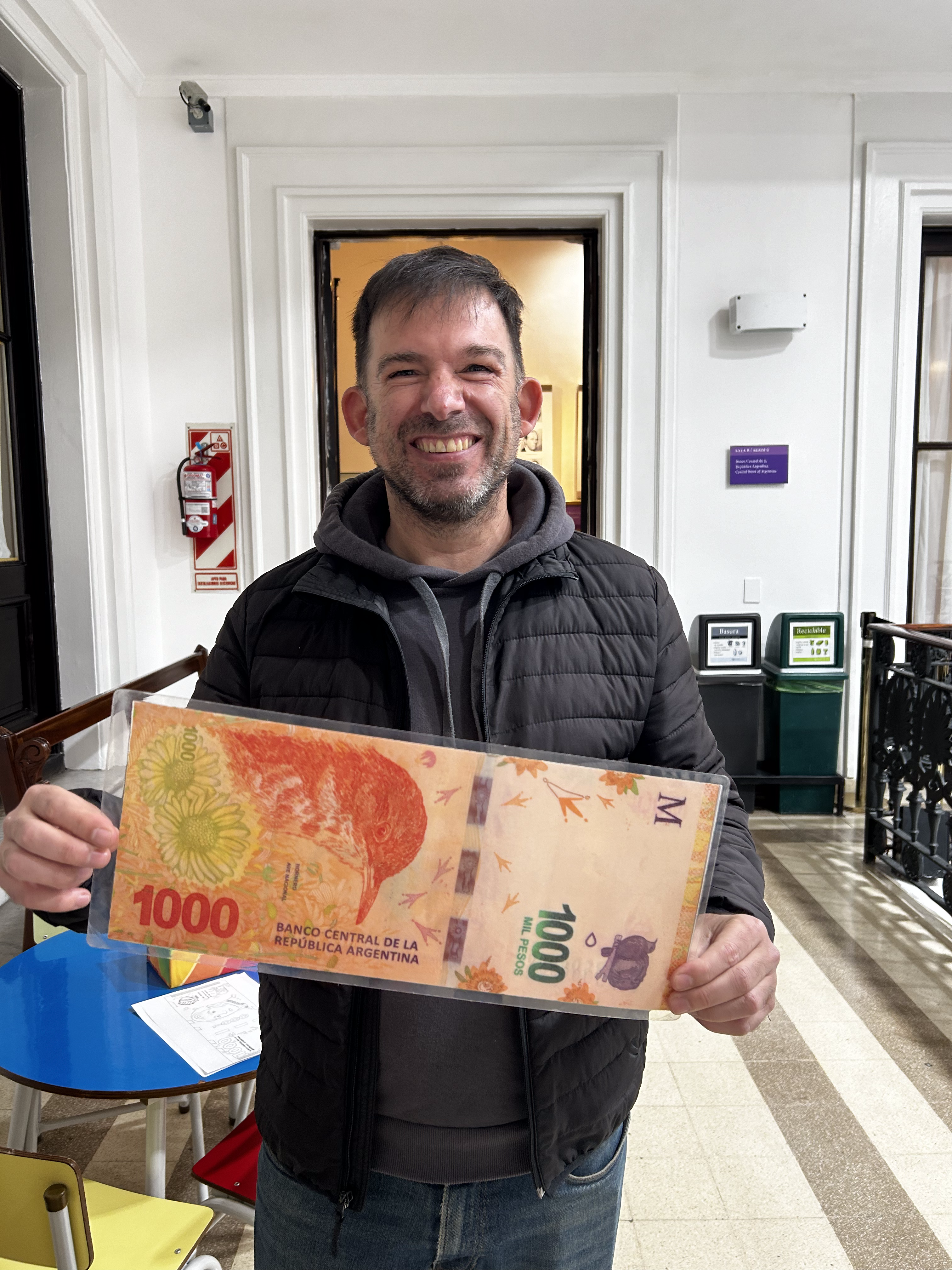 Jerónimo Ferrer exhibant fièrement un billet de 1000 pesos au Musée de la Banque Centrale Argentine